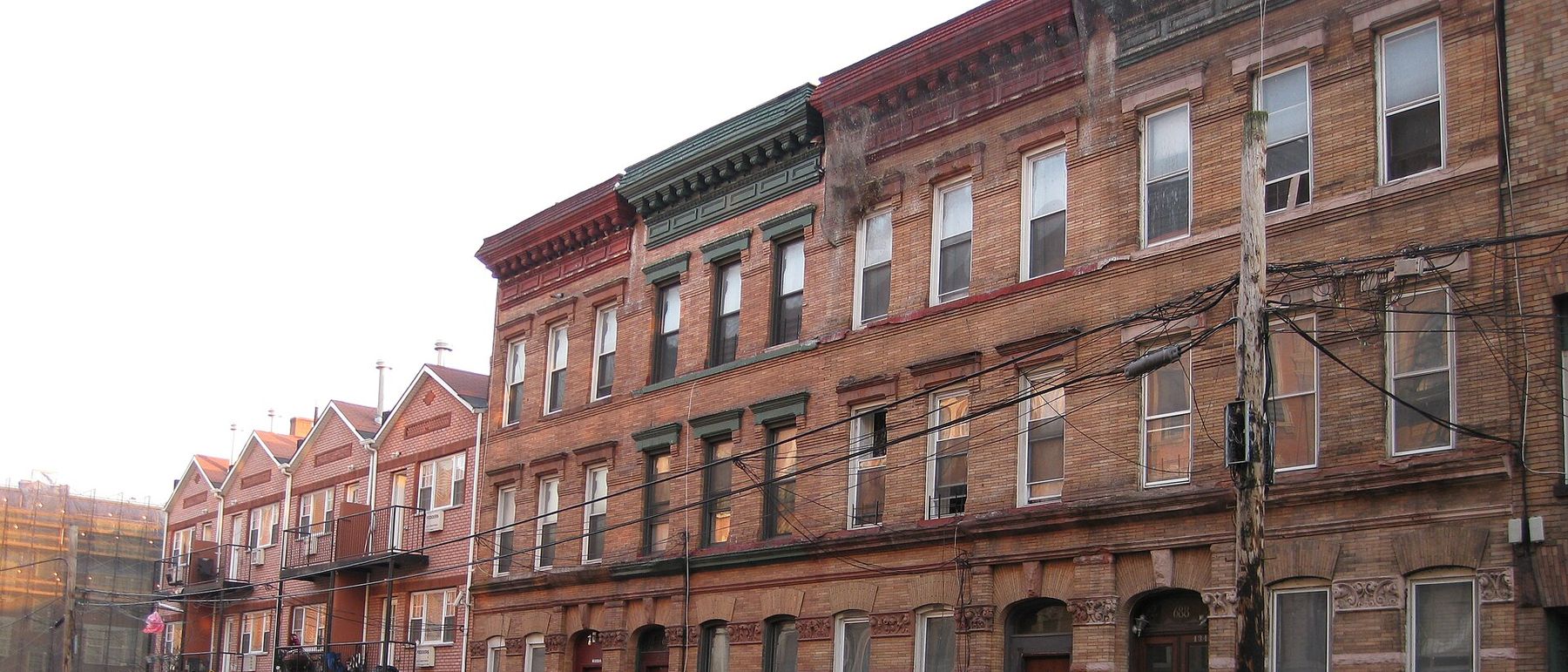 Row of brick and brownstone houses on East 136th Street in Mott Haven, the Bronx